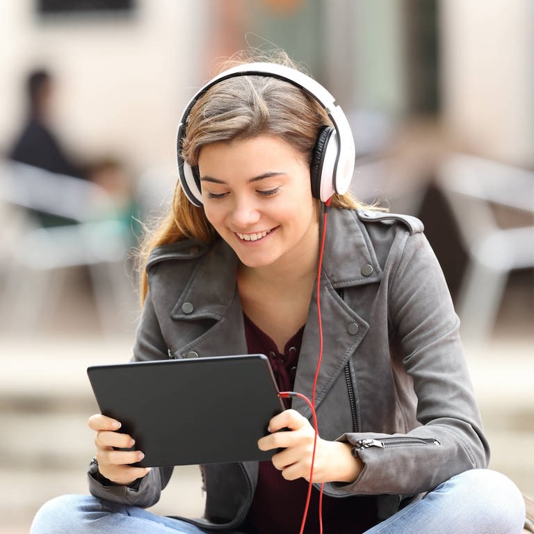 Teenager am Tablet mit Kopfhörern