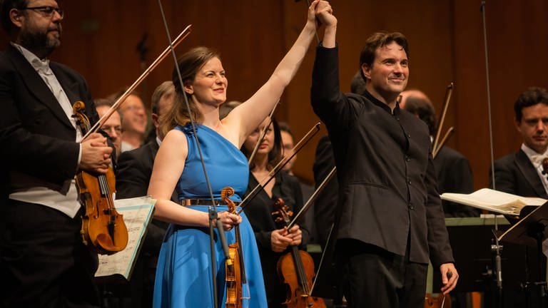 Veronika Eberle (Violine) und Alexander Soddy (Dirigent)  beim Schlussapplaus auf der Bühne 