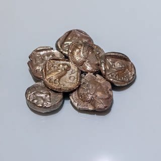 Sieben silberne athenische Tetradrachmen. Wweit verbreitete Münze der klassischen Periode des 5. Jahrhunderts v. Chr. im antiken Griechenland. Sie stellen die Göttin Athene dar, Beschützerin der Stadt, mit ihrem Symbol, der Eule.