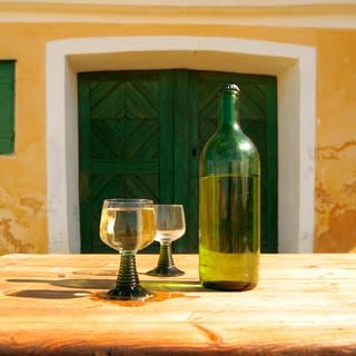 Konzeptaufnahme von einem Glas Wein und einer Flasche Wein vor einem Keller im Weinviertel in Niederösterreich