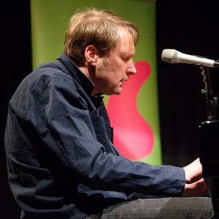 Jens Thomas sitzt bei einer Veranstaltung im Rahmen des Literaturfestivals  Lit. Cologne auf der Bühne 