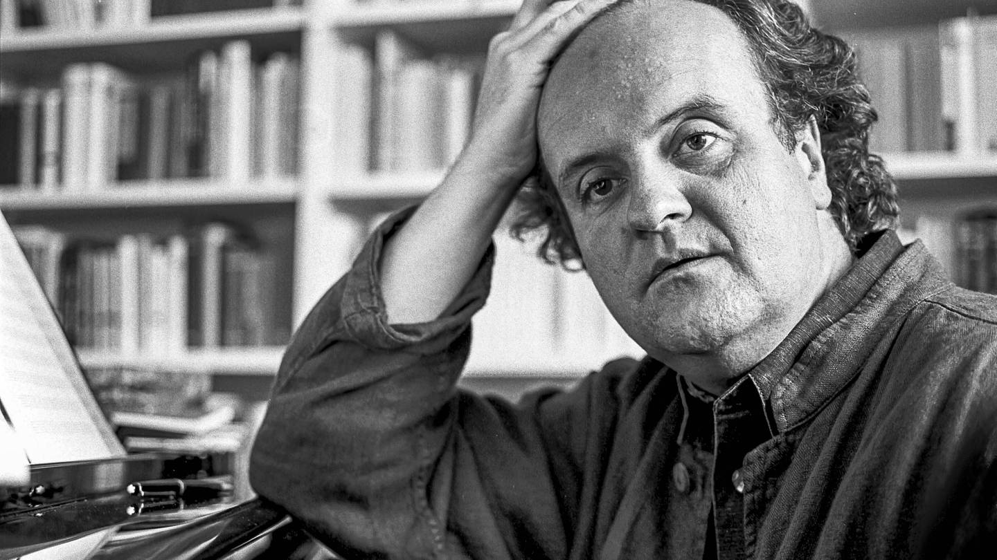 Wolfgang Rihm in einer Schwarz-weiß-Aufnahme, am Flügel sitzend, Zigarre in der Hand