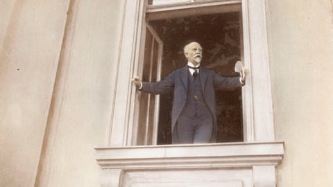 Philipp Scheidemann steht an einem Fenster der Berliner Reichskanzlei und ruft die Republik aus.