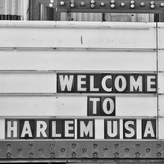 Schild "Welcome to Harlem" in schwarz-weiß