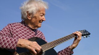 eine ältere Dame spielt Gitarre