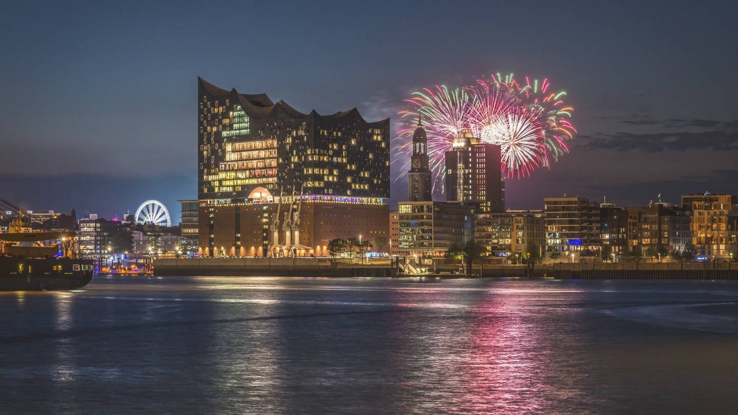 Eines der bekanntesten Konzerthäuser in Deutschland: Die Elbphilhamonie in Hamburg mit einem Feuerwerk im Hintergrund