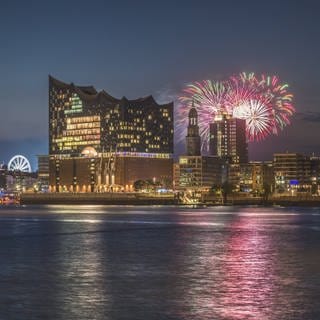 Eines der bekanntesten Konzerthäuser in Deutschland: Die Elbphilhamonie in Hamburg mit einem Feuerwerk im Hintergrund