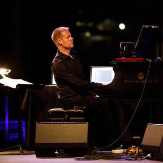 Komponist Max Richter spielt am Klavier, daneben ein Computer.