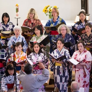 Der deutsch-japanische Chor „Der Flügel“ Karlsruhe bei einem Konzert, gekleidet in bunten japanischen Gewändern