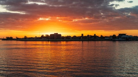 Sonnenaufgang über dem Mississippi. Im Hintergrund das französische Viertel in New Orleans.