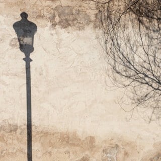 Schatten einer alten Straßenlaterne und eines Baumes