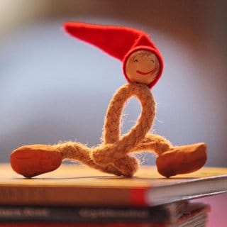 Ein Nisse sitzt auf einem Buch. Ein Nisse ist eine Art Kobold, der in der dänischen Weihnachtstradition eine wichtige Rolle spielt. 