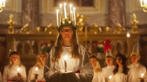 Schwedische Lichterkönigin Lucia mit einem brennenden Kerzenkranz auf ihrem Kopf im Berliner Dom bei einem Adventskonzert (2012)