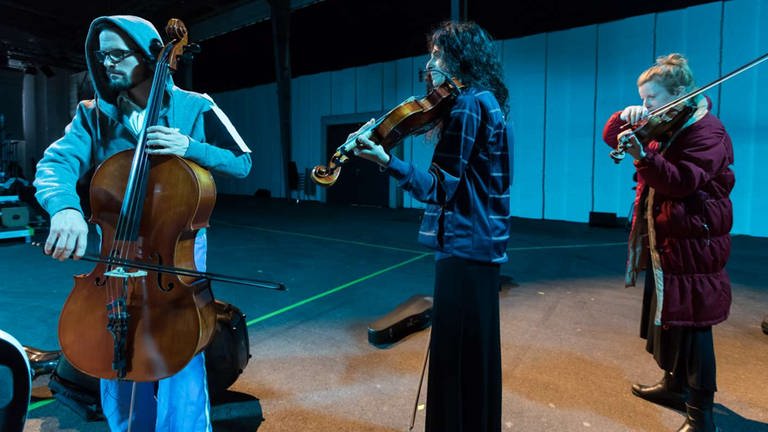 Drei Musiker spielen im Stehen bei Proben zum Konzert "Transit" in den Donauhallen