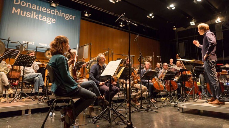 Orchester probt auf der Bühne mit DIrigent