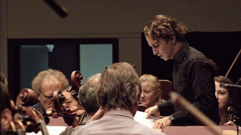 Junger Mann dirigiert Orchester