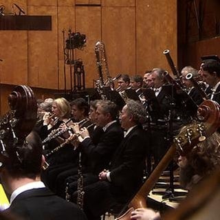 SWR Symphonieorchester auf der Bühne, durch ein Bullaugenfenster gesehen