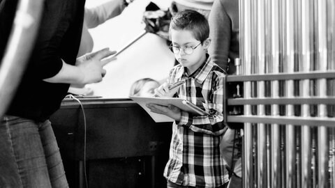 Ein Junge mit Downsyndrom konzentriert sich auf Noten. Er ist Teil des inklusiven Musikprojekts "YouTH-Rock it!" 