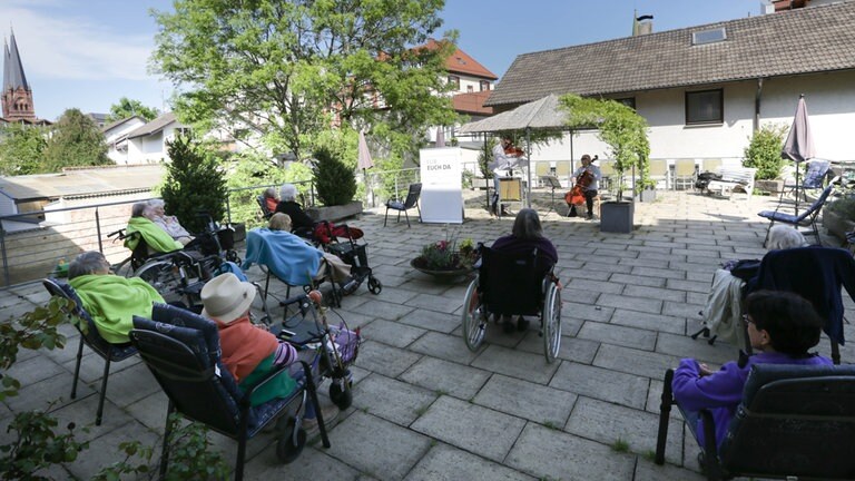 Musiker spielen vor Publikum auf einer Terrasse