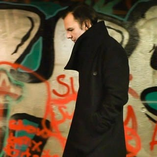 Teodor Currentzis vor einer Graffiti-Wand