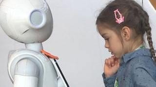 Kind begegnet humanoidem Roboter