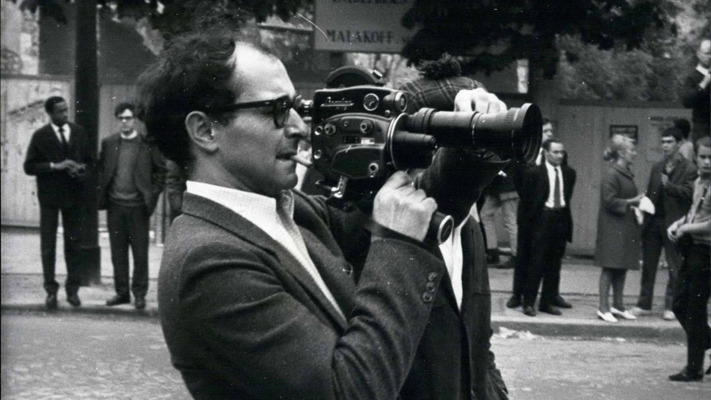 Der Regisseur Jean-Luc Godard filmt mit einer Kamera