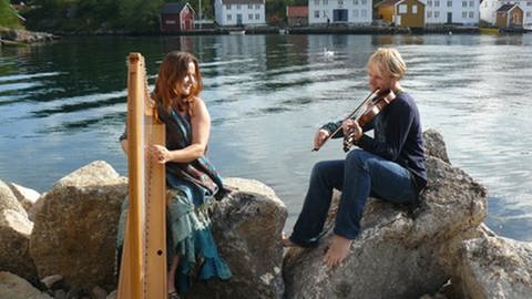 Arianna Savall spielt an einem Fluss Harfe