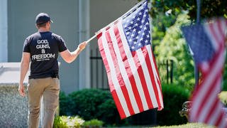 God, Guns & Freedom: Ein Mann mit der US-Flagge bei Protesten am 2. Mai 2020 in Morganton  North Caroline. Gut 50 Menschen forderten den Gouverneur von North Carolina, Roy Cooper, auf, die Beschränkungen, die wegen der COVID-19-Pandemie verhängt worden waren, zu lockern. 