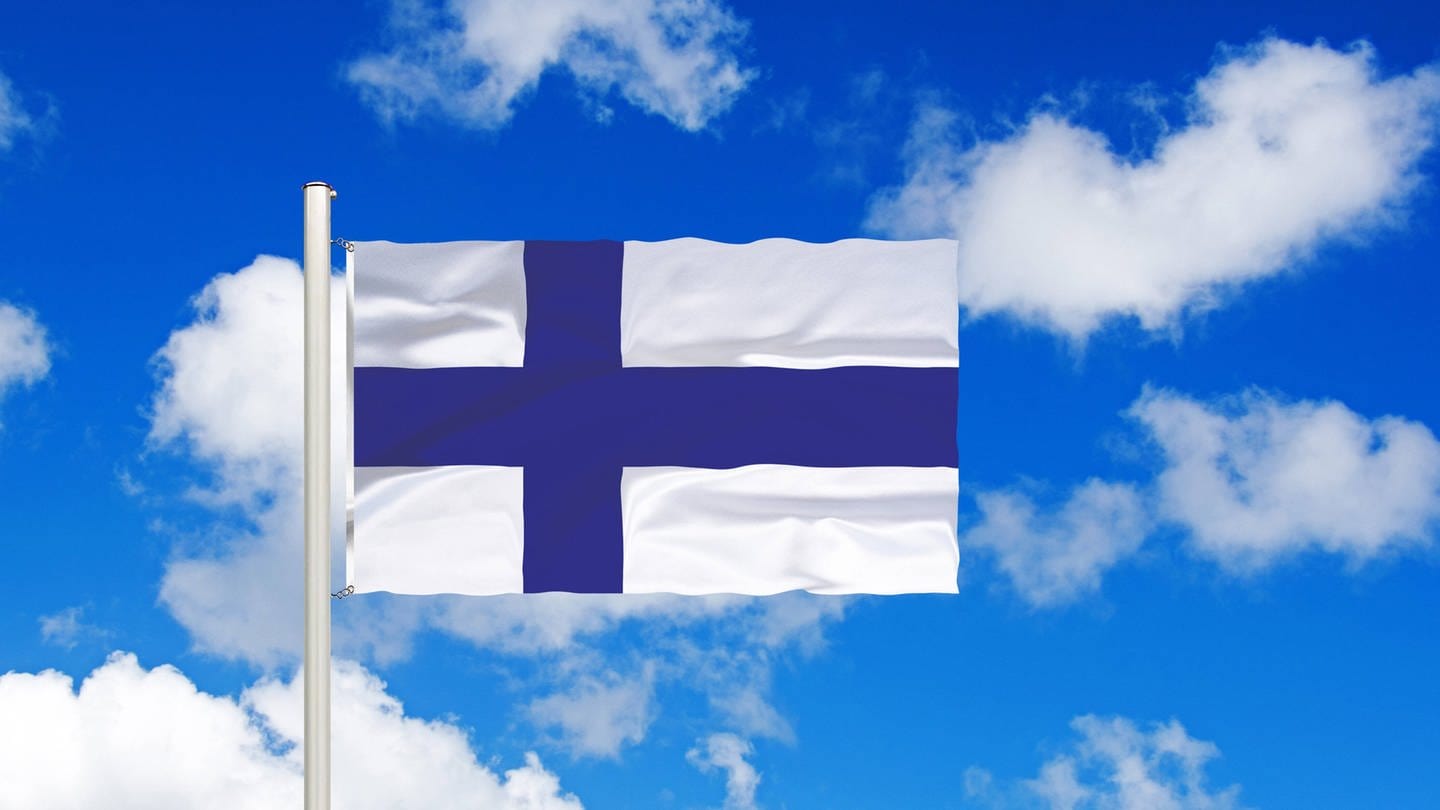 Flagge von Finnland vor blauem Himmel mit weißen Wolken