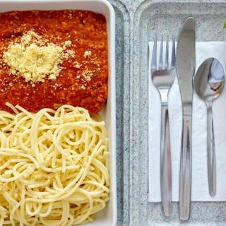 Essenstablett mit Spaghetti, Salat und Kompott: Gemüse, das stundenlang warmgehalten wird, zerkochte Nudeln, fades Fleisch oder klebriger Brei: In Pflegeheimen und Krankenhäusern verstößt das Speisenangebot mitunter gegen die Menschenwürde. 