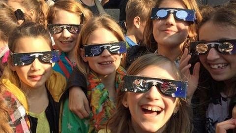 Junge Leute mit Sonnenfinsternis-Brillen