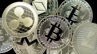 Münzen populärer Kryptowährungen wie Ripple, Bitcoin und Ethereum