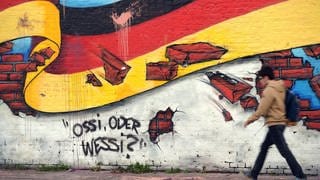 Wandbild in Berlin 2015 mit der deutschen Nationalflagge und dem Schriftzug "Ossi oder Wessi?"