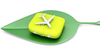 Weißes Flugzeug auf gelbem Koffer auf grünem Blatt (Grafik): Der Tourismus verursacht acht Prozent der weltweiten Treibhausgasemissionen. Bei der Urlaubsplanung spielt Nachhaltigkeit bisher aber für die wenigsten eine Rolle.