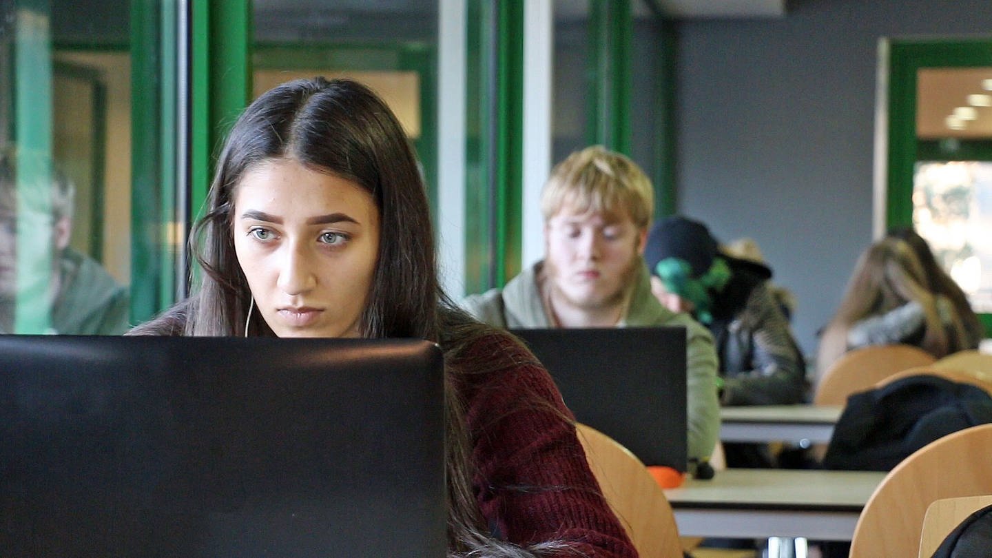 Eine Schülerin sitzt am Laptop