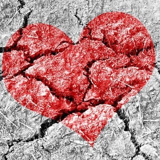 Ein rotes Herz auf einem brüchigen Boden