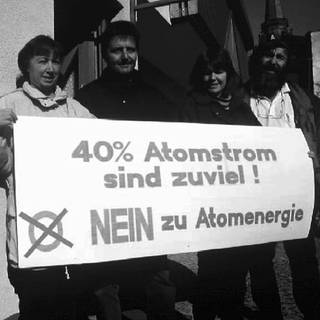 Mitglieder der Bürgerinitiative "Netzkauf" des Schwarzwaldstädtchens Schönau im März 1996 mit einem Transparent vor dem Büro und dem Logo der von ihr ins Leben gerufenen Elektrizitätswerke Schönau (EWS)