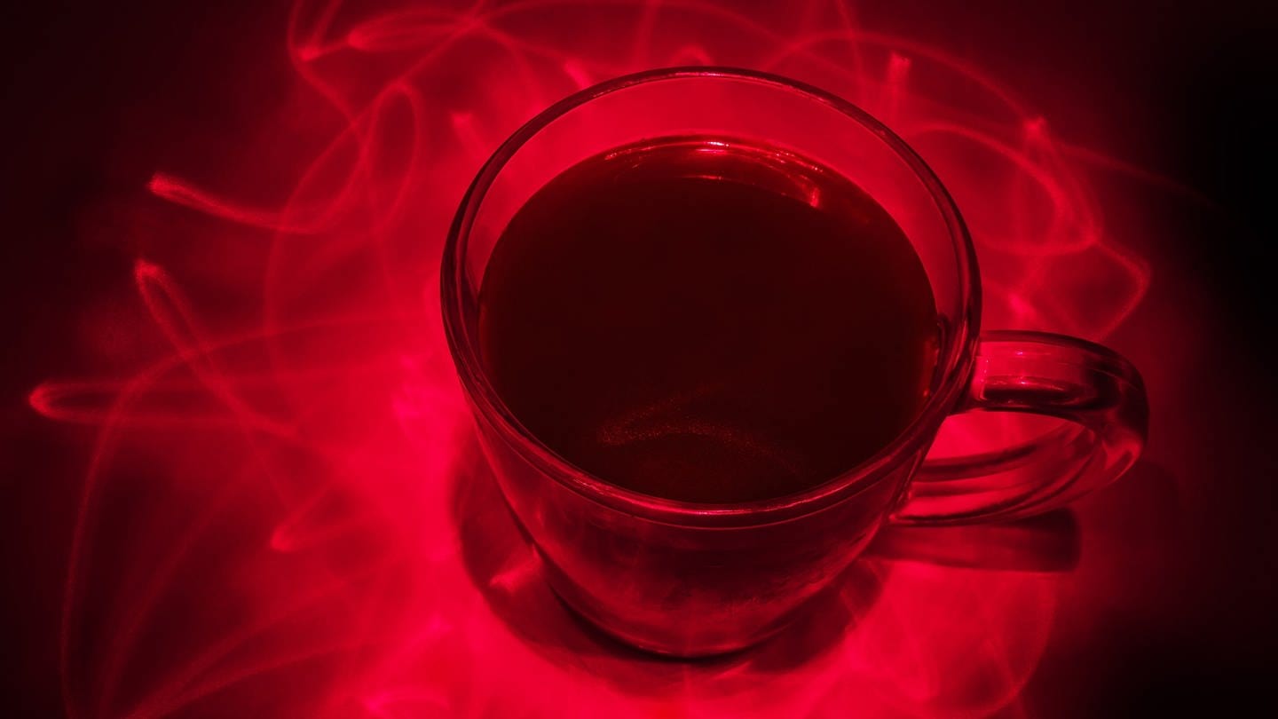 Eine Tasse Kaffee mit Laserstrahlen drumrum