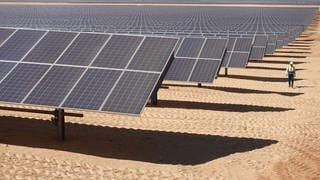 Arbeiter unterwegs im Solarpark Benban in Ägypten. Mit einer Fläche, die mehr als 50 Fußballfeldern entspricht, ist Benban inzwischen auf Satellitenfotos aus dem Weltall zu sehen.