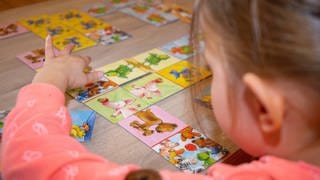 Mädchen spielt mit Bildkarten: Die Sprach-Kitas gelten als sehr erfolgreich, damit kleine Kinder gut Deutsch lernen können. Trotzdem soll das Programm Mitte 2023 auslaufen. Wie geht es weiter mit der Sprachbildung?