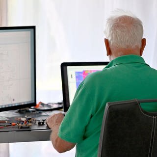 Ein Senior arbeitet in seiner Elektronik-Werkstatt