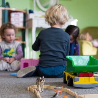 Kleine Kinder spielen auf dem Boden einer Kindertagesstätte.