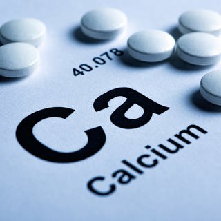 Symbol des chemischen Elements Kalzium und weiße Pillen.
