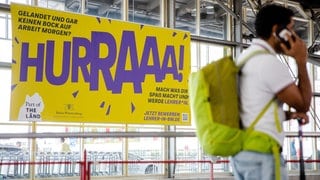 Ein Werbeplakat für den Beruf des Lehrers hängt am Flughafen in Stuttgart. 