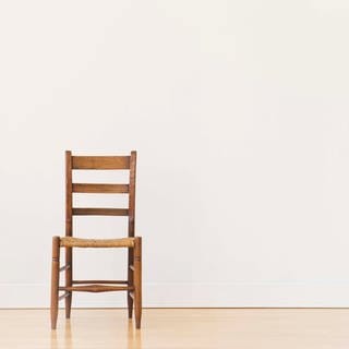 Ein einzelner Stuhl steht in einem leeren Raum.