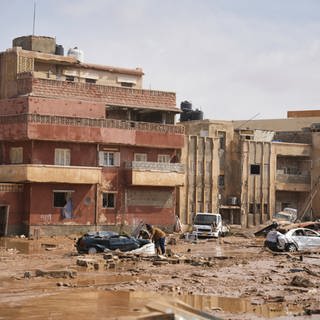 Auf diesem Bild liegen Autos und Trümmer in einer Straße in Darna, Libyen