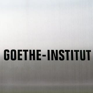 Das Logo des Goethe Institutes auf einer polierten Stahlplatte.