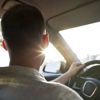 Symbolfoto: Junger Mann im Auto