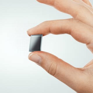 Eine Solarzelle gehoben von 2 Fingern
