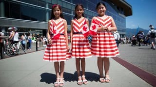 Die Drillinge Elizabeth, Danielle und Chloe, die in den Vereinigten Arabischen Emiraten geboren wurden, posieren für ein Foto, nachdem sie während einer besonderen Zeremonie zum Canada Day in Vancouver, B.C., ihre kanadische Staatsbürgerschaft erhalten haben